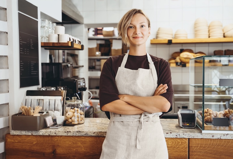 Smiling,female,baker,entrepreneur,standing,at,the,counter,of,bakery